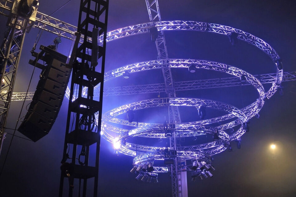 Stage lighting trusses and speakers lit in blue